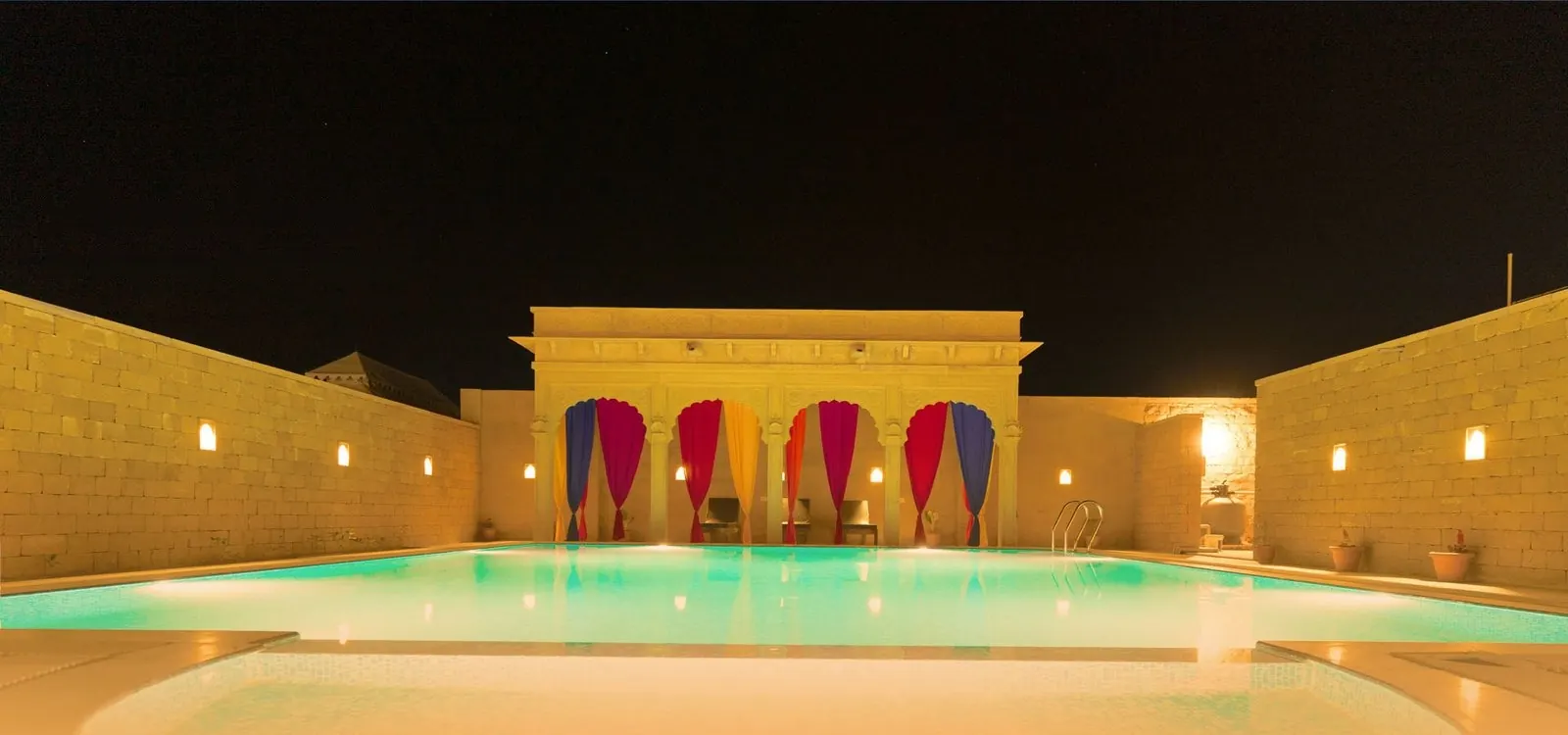 The swimming pool at Desert Dream Royal Camp, lit up at night