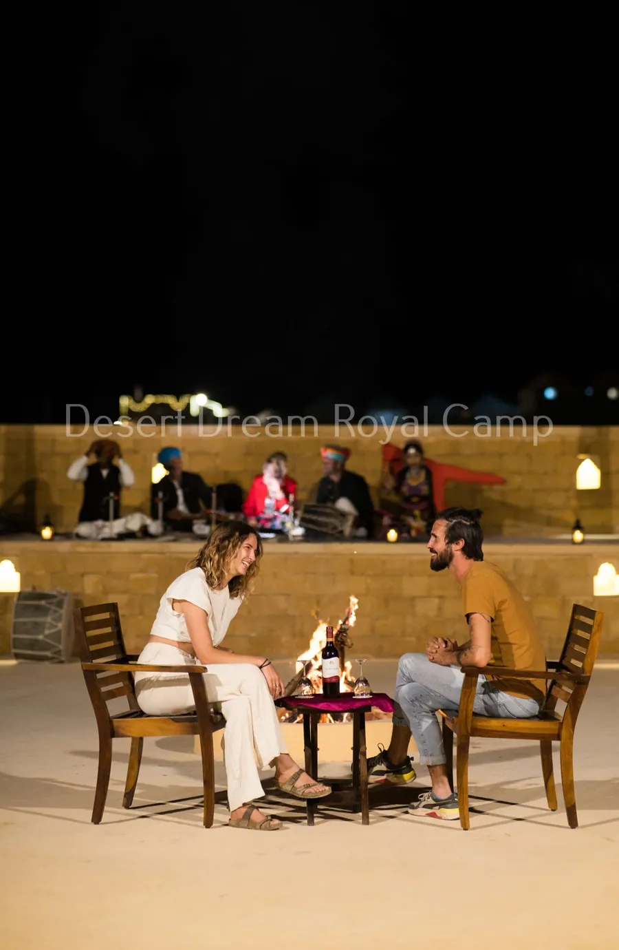 Guests dining outdoors at the camp at night